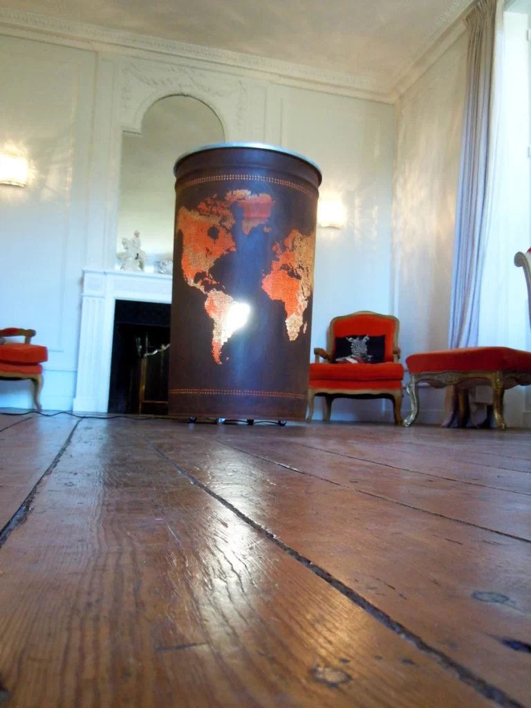 Photo du bidon rouillé représentant un planisphère avec un lumière à l'intérieur. Il sert d'éclairage d'ambiance dans un salon.